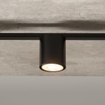 Lampa sufitowa Sky 3-punktowa w kolorze czarnym, z metalowym kloszem, montowana na suficie. Ujęcie z bliska na jeden z punktów świetlnych, z widocznym żarówkowym źródłem światła. Tło w neutralnym kolorze, podkreślającym minimalistyczny design.