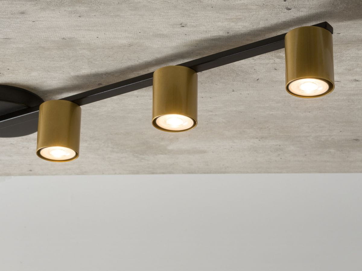 Lampa sufitowa Sky 5-punktowa z czarnym stelażem i złotymi kloszami. Ujęcie z góry, ukazujące trzy złote klosze z widocznymi źródłami światła. Montowana na suficie, idealna do nowoczesnych wnętrz.