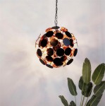 Czarna lampa wisząca Discus 4-punktowa z okrągłymi, metalowymi elementami, w kształcie kuli. Ujęcie z góry, z widocznym łańcuchem. W tle liście rośliny, na jednolitym tle.