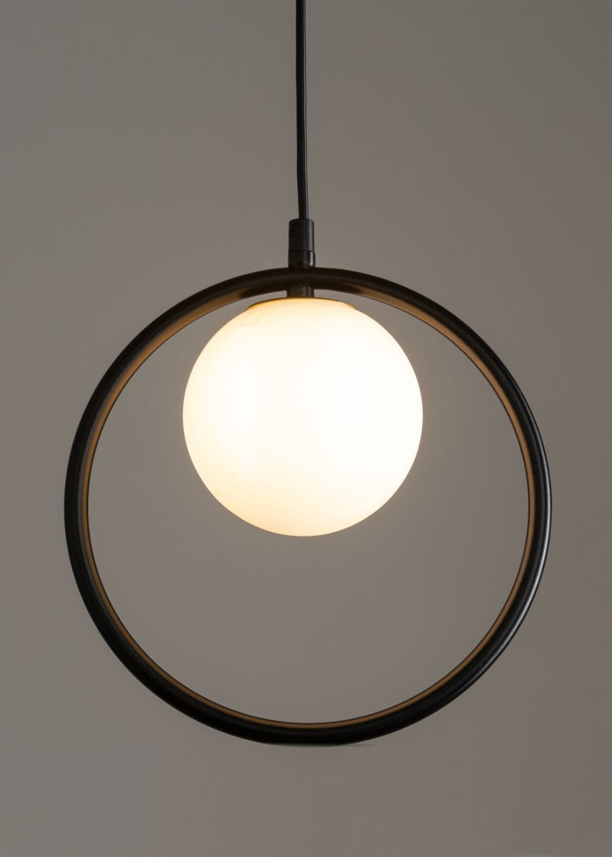 Lampa wisząca Aqua 1-punktowa w kolorze czarnym ze złotymi akcentami. Posiada okrągłą konstrukcję z metalowym pierścieniem oraz mleczną kulę. Zawieszona na cienkim kablu, idealna do nowoczesnych wnętrz.