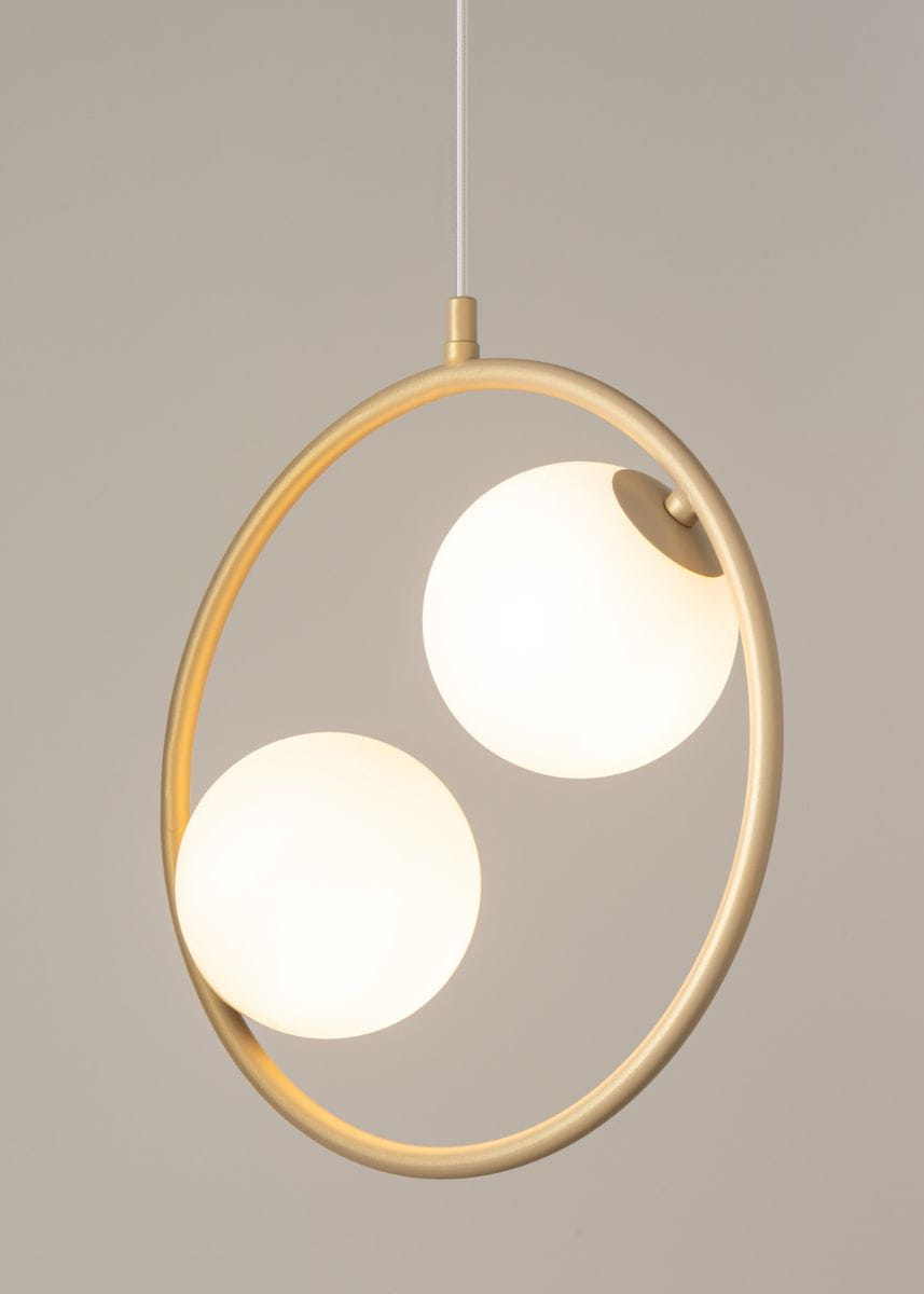 Lampa wisząca Aqua 2-punktowa w złotym kolorze, z okrągłą konstrukcją. Dwa białe, matowe klosze w kształcie kul umieszczone w metalowej ramie. Lampa zwisa na białym przewodzie, z delikatnym tłem w odcieniu szaro-beżowym.
