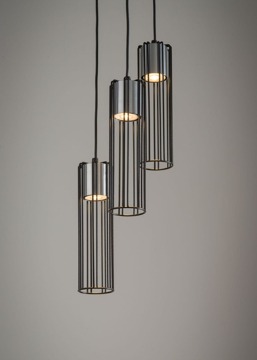 Lampa wisząca Fobia 3-punktowa w kolorze czarnym i srebrnym. Składa się z trzech cylindrycznych kloszy z metalowymi prętami, zawieszonych na czarnych kablach. Klosze mają widoczne źródła światła w środku, umieszczone w górnej części.