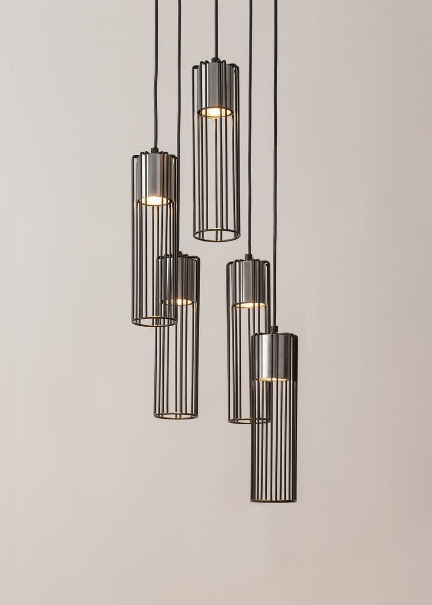 Lampa wisząca Fobia 5-punktowa w kolorze czarnym i srebrnym, składająca się z pięciu cylindrycznych kloszy z metalowymi szczelinami. Produkt zawieszony na czarnych przewodach, ukazany na jasnym tle.