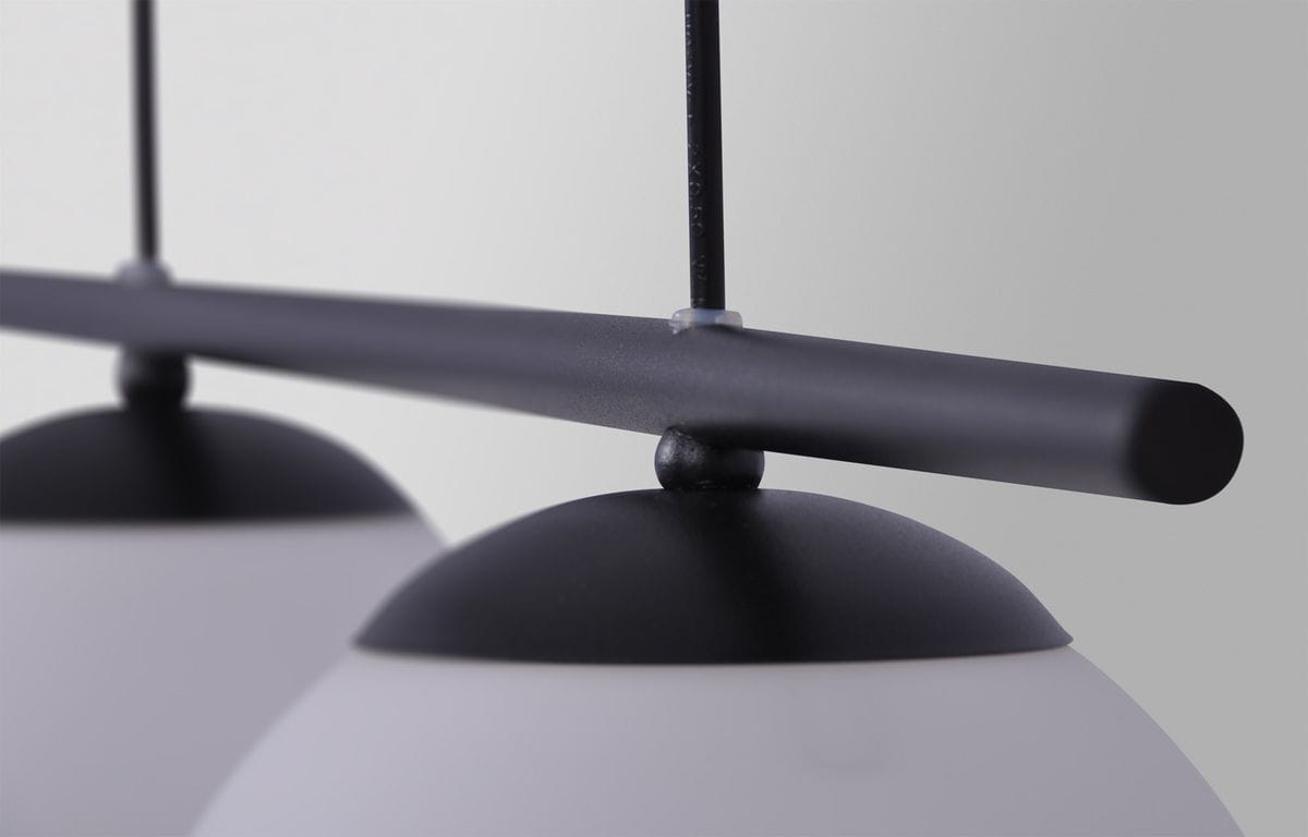 Czarna lampa wisząca Arton 2-punktowa K-4965 z metalowym stelażem i okrągłymi kloszami. Ujęcie z bliska, pokazujące detal mocowania oraz górną część lampy. Klosze mają matową powierzchnię, a całość ma minimalistyczny design.