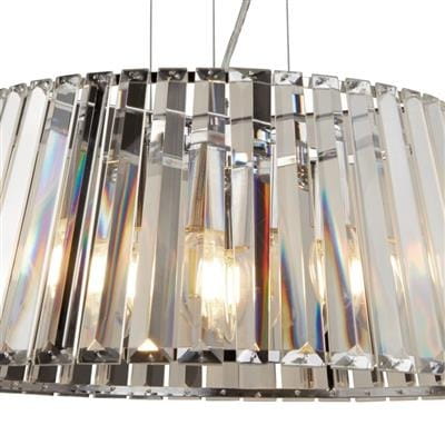 Lampa wisząca Tiara 5-punktowa, chromowana z przeźroczystymi elementami. Okrągły klosz z prostokątnymi, szlifowanymi detalami, ukazującymi refleksy świetlne. Widoczne źródła światła w środku, zawieszona na cienkich linkach.