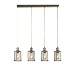Lampa wisząca 4-punktowa Pipes w antycznym mosiądzu, z czterema kloszami w kształcie cylindrów z przezroczystego szkła, zawieszona na prostokątnej podstawie. Klosze mają metalowe ramki, a każdy z nich zawiera żarówkę.