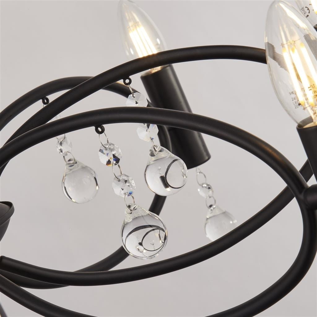 Czarna lampa wisząca Infinity 8-punktowa, z metalowym stelażem w kształcie falistych ramion. Widoczne kryształowe dekoracje w formie kropli oraz żarówki o stożkowym kształcie. Ujęcie z bliska, z wyeksponowanymi detalami i teksturą.