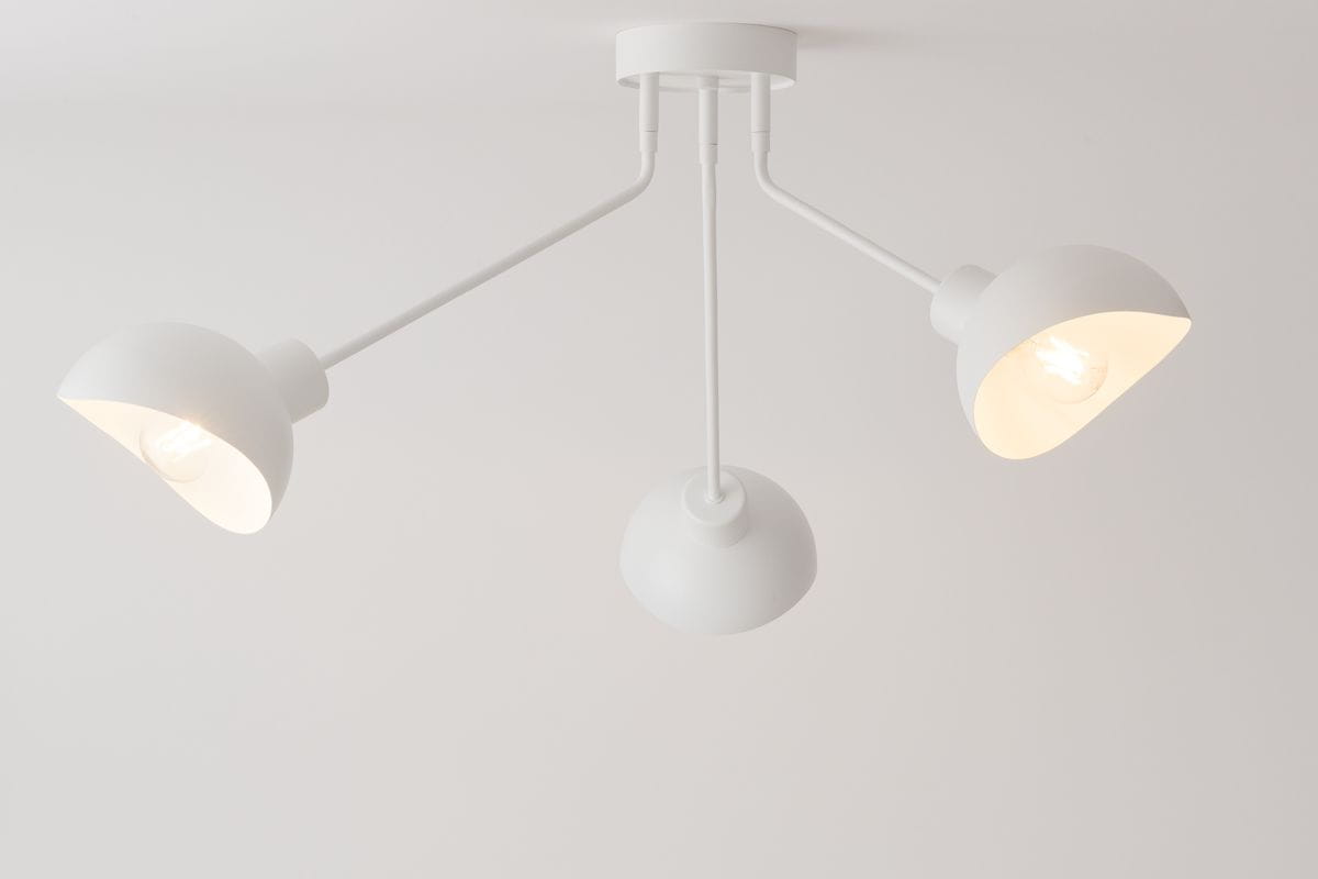 Lampa sufitowa 3-punktowa Roy w kolorze białym, z trzema kloszami w kształcie miseczek zamocowanymi na ruchomych ramionach. Ujęcie z dołu, pokazujące lampę w pozycji montażu sufitowego, na jednolitym jasnym tle.