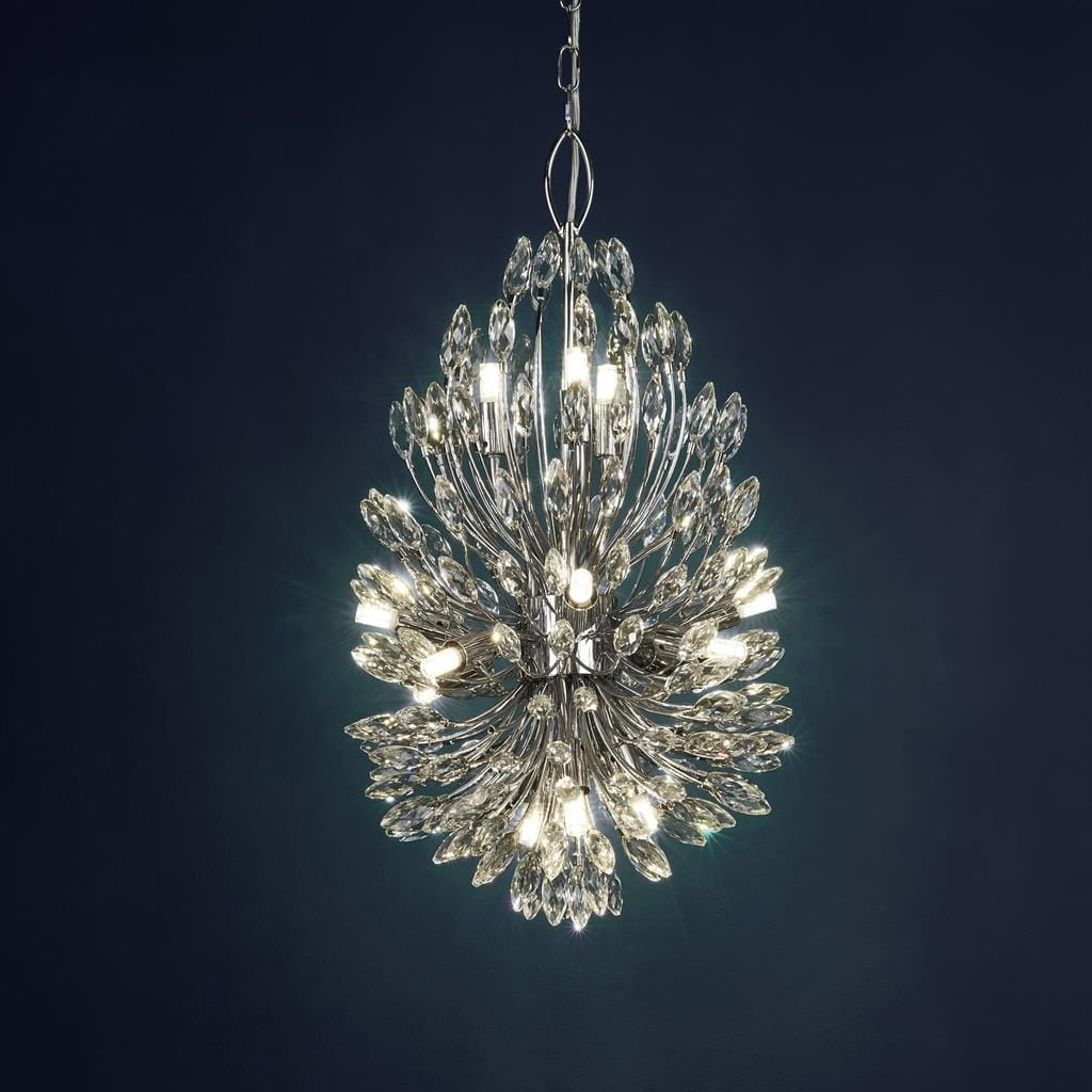 Lampa wisząca Peacock 14-punktowa w chromowanej obudowie, z dekoracyjnymi kryształowymi elementami. Produkt zawieszony na łańcuchu, o kształcie przypominającym rozkwitający kwiat, emituje ciepłe światło z 14 żarówek. Tło ciemnoniebieskie.