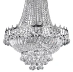 Żyrandol Versailles 9-punktowy w chromie, ozdobiony kryształowymi elementami. Posiada elegancką, falistą krawędź oraz wiszące, diamentowe detale. Ujęcie z góry, ukazujące detale i fakturę kryształów.