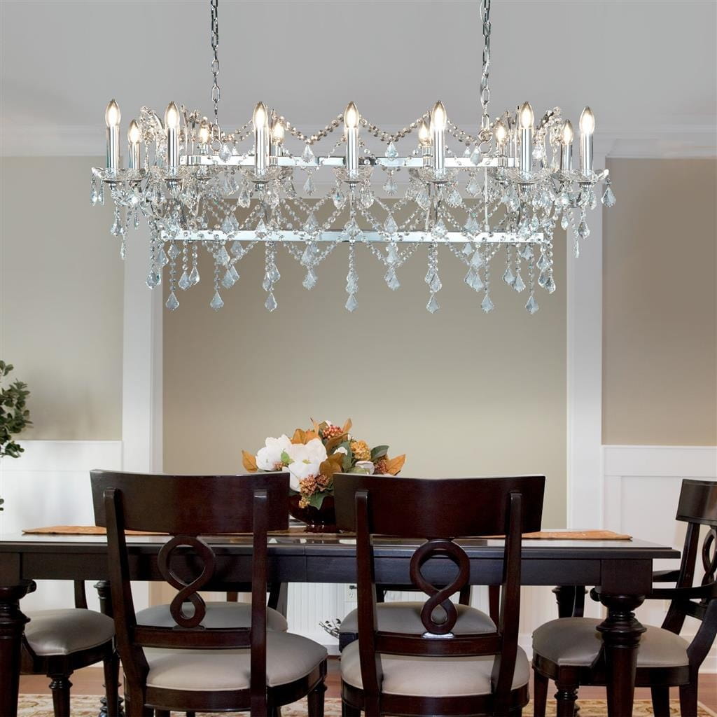 Lampa wisząca Florence 14-punktowa w chromie, z kryształowymi zwisami i oświetleniem w kształcie świec. Zawieszona nad drewnianym stołem, otoczona krzesłami z ciemnego drewna. Tło w neutralnym kolorze, podkreślające elegancję lampy.
