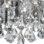 Lampa sufitowa Hanna 4-punktowa, okrągła, w kolorze chromu. Wyposażona w kryształowe dekoracje w kształcie diamentów oraz metalowe elementy. Widok z bliska, ukazujący detale kryształów i źródła światła.