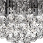 Lampa sufitowa Hanna 4-punktowa, okrągła, w kolorze chromu. Elementy zdobione przezroczystymi, kryształowymi kulami, które odbijają światło, tworząc efektowne refleksy. Ujęcie z bliska na detale i teksturę kryształów.