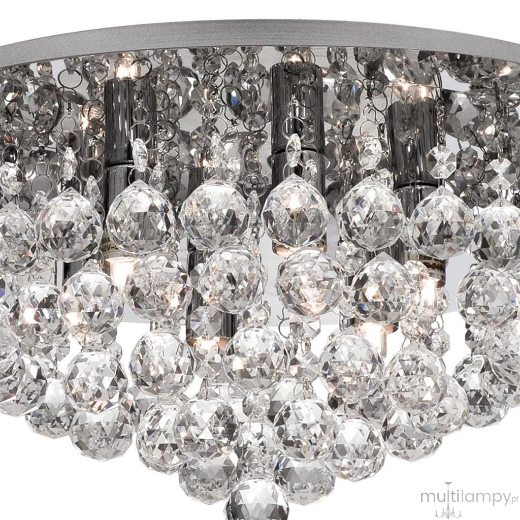 Lampa sufitowa Hanna 6-punktowa, okrągła, w kolorze chromu. Posiada szereg kryształowych akcentów, które odbijają światło, tworząc efektowną iluminację. Widoczna jest struktura metalowa oraz sześć miejsc na żarówki.