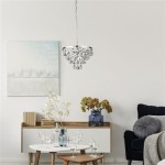 Lampa wisząca Michelle 4-punktowa w chromowanym wykończeniu, z kryształowymi detalami, zawieszona nad stołem w nowoczesnym wnętrzu. Tło jasne, z obrazem oraz dekoracjami na komodzie.