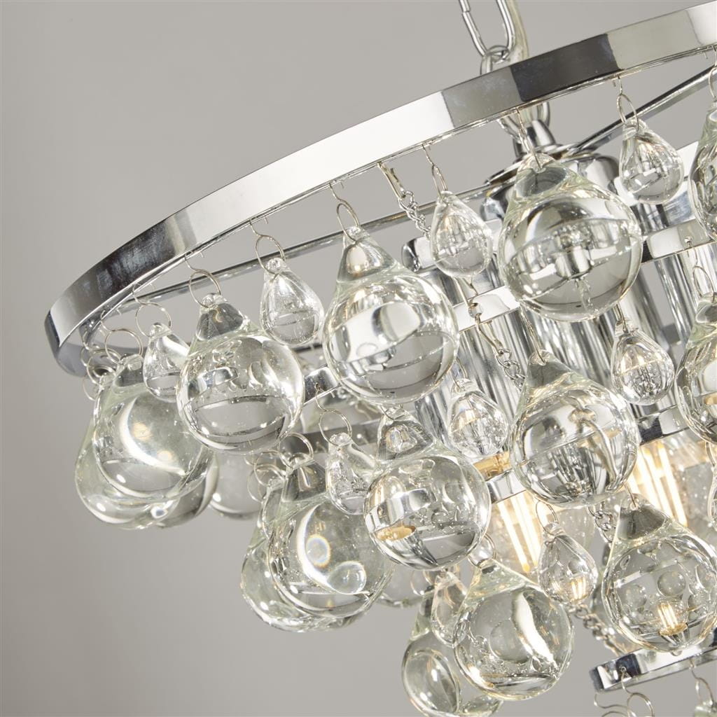 Lampa wisząca Michelle 4-punktowa w chromie, z okrągłym metalowym ramieniem, zdobiona przezroczystymi, szklanymi kulkami w różnych kształtach. Widok z góry, akcentujące detale i blask kryształów.