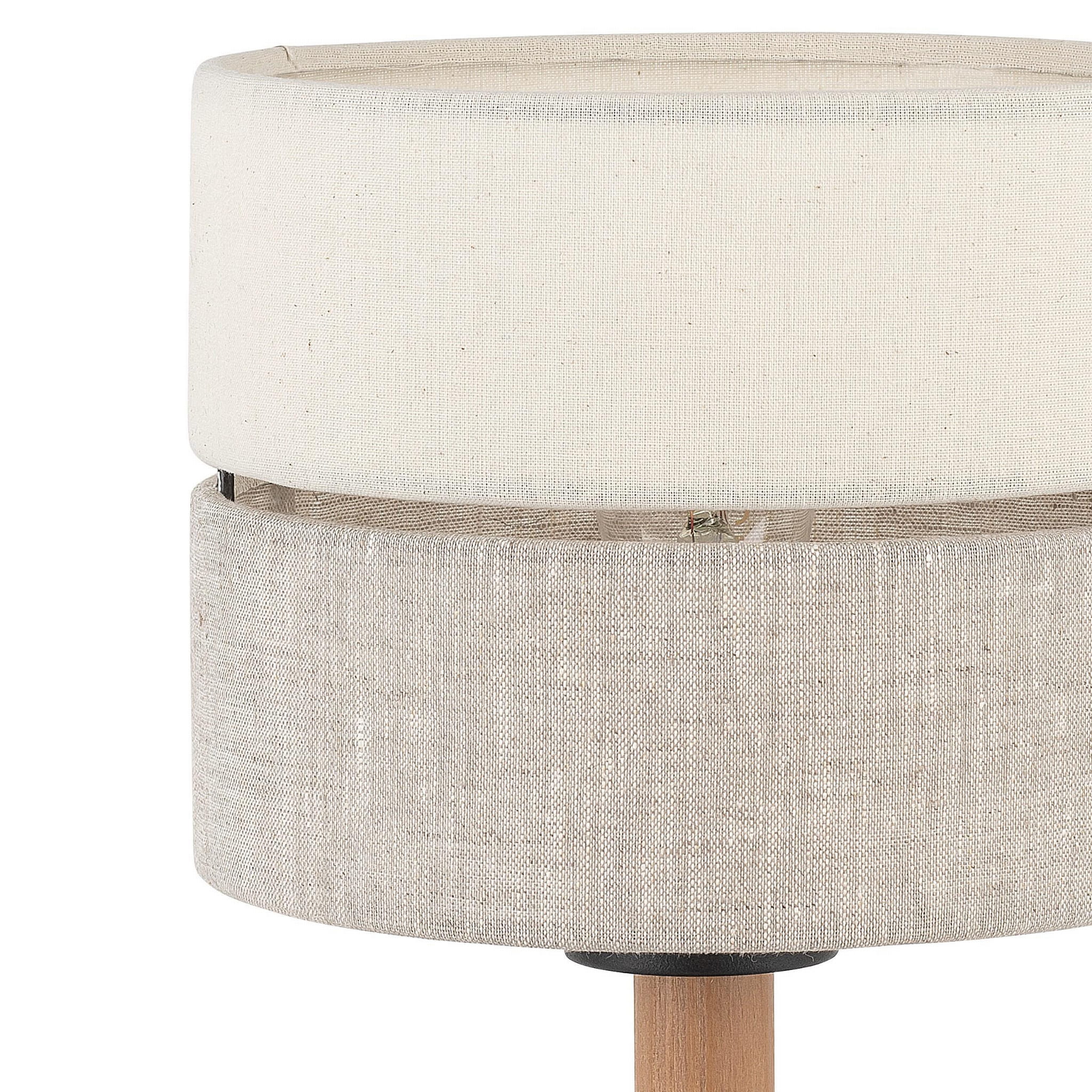 Eco lampa stołowa 1-punktowa 5596 z podwójnym kloszem w odcieniach jasnego beżu i naturalnego lnu. Ustawiona na drewnianej podstawie, z widocznym detalem mocowania. Klosze mają okrągły kształt i teksturowaną powierzchnię.