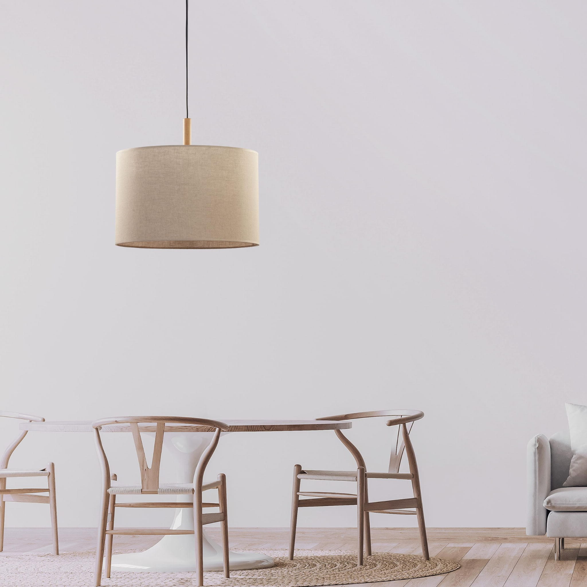 Lampa wisząca Deva Nature 1-punktowa 6107 o okrągłym, jasnobeżowym kloszu z tkaniny, zawieszona na czarnym przewodzie. W tle widoczna drewniana stół z krzesłami w skandynawskim stylu, na jasnym tle.