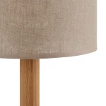 Lampka stołowa Deva Nature 1-punktowa, z okrągłym kloszem w jasnym, teksturowanym materiale, na drewnianej nodze o naturalnym wykończeniu. Widok z boku na detale klosza i podstawy. Idealna do minimalistycznych aranżacji.