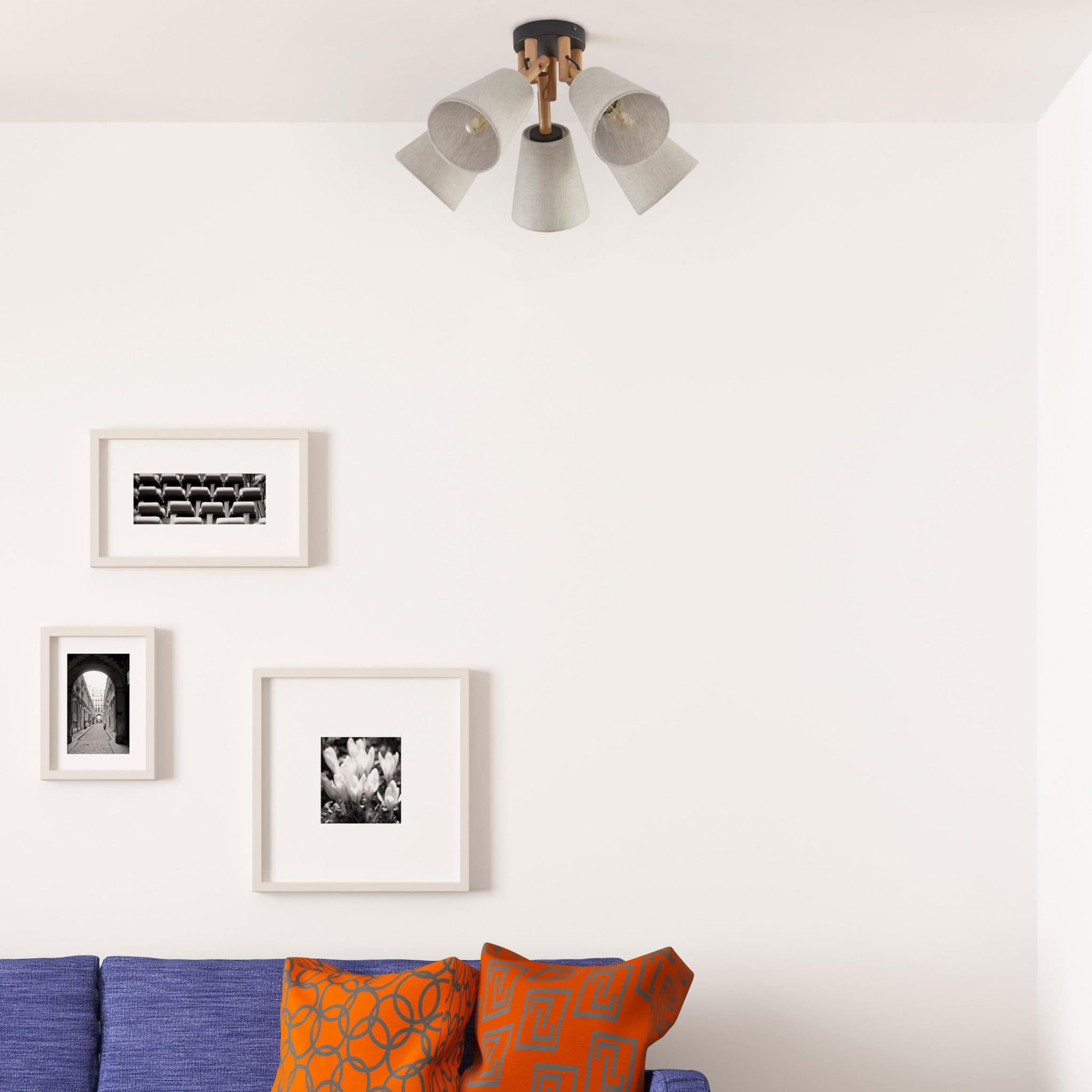 Vaio lampa sufitowa 5-punktowa w czarnym kolorze, z metalowymi kloszami w odcieniu szarym, zamontowana na suficie. Widoczne są również kolorowe poduszki na niebieskiej kanapie oraz obrazy na białej ścianie.