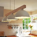 Lampa wisząca Oslo 3-punktowa w kolorze białym z metalowymi kloszami w kształcie półkuli, zawieszona na drewnianym stelażu. Widok z przodu, w kuchennej aranżacji z oknem w tle oraz akcesoriami kuchennymi.