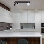 Albio lampa sufitowa 3-punktowa w kolorze czarnym, zamocowana na prostokątnej listwie. Dwa ruchome reflektory oraz jedna okrągła, biała oprawa. Lampa zawieszona w nowoczesnej kuchni z jasnymi szafkami i białym blatem.