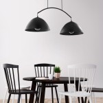 Lampa wisząca Faro 2-punktowa w kolorze czarnym z dwiema półkulistymi kloszami, zawieszona nad okrągłym stołem w jadalni. W tle białe ściany i drewniana podłoga, obok czarne i białe krzesła oraz doniczka z rośliną.