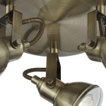 Lampa sufitowa Focus 3-punktowa w antycznym mosiądzu. Trzy ruchome reflektory zamocowane na okrągłej podstawie. Widoczne detale metalowe i tekstura powierzchni. Kąt ujęcia z dołu, ukazujący konstrukcję i mocowania.