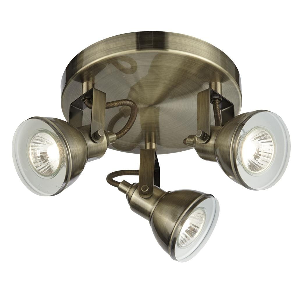 Lampa sufitowa Focus w kolorze antycznego mosiądzu, 3-punktowa. Posiada okrągłą podstawę i trzy regulowane reflektory, każdy z przezroczystą szybą. Ujęcie z dołu, eksponujące detal konstrukcji oraz kierunek światła.
