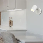 Biały kinkiet Rollo LED (spot) 1-punktowy, zamontowany na ścianie, z cylindrycznym kloszem skierowanym w dół. Oświetlenie umieszczone nad blatem, w tle widoczna jasna powierzchnia robocza i szafki kuchenne.