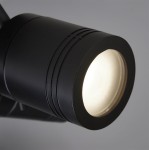 Czarna lampa sufitowa (spot) Samson IP44, 3-punktowa, z widoczną oprawą w kształcie cylindra. Zbliżenie na reflektor z białą soczewką, matowe wykończenie, z widocznymi detalami na powierzchni. Ujęcie z boku, na szarym tle.