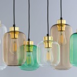 Lampa wisząca Marco Green 6-punktowa 3328 z sześcioma szklanymi kloszami w odcieniach zieleni i brązu, z metalowymi złotymi detalami. Klosze mają różne kształty i są zawieszone na czarnych przewodach, tworząc nowoczesną aranżację.