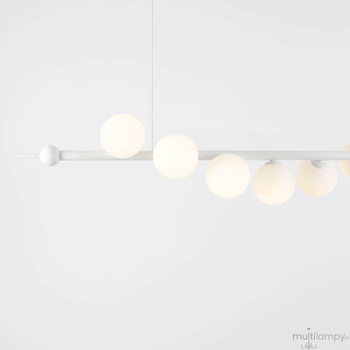 Lampa wisząca Wave 7-punktowa w białym kolorze, z prostą belką i sześcioma okrągłymi kloszami z matowego szkła, zawieszona na cienkich linkach. Całość na jasnym tle, co podkreśla nowoczesny design i minimalistyczny styl.