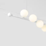 Lampa wisząca Wave 7-punktowa w kolorze białym, z prostą, białą listwą, na której umieszczono sześć matowych, okrągłych kloszy. Ujęcie z góry, ukazujące detale konstrukcji oraz rozmieszczenie kul.