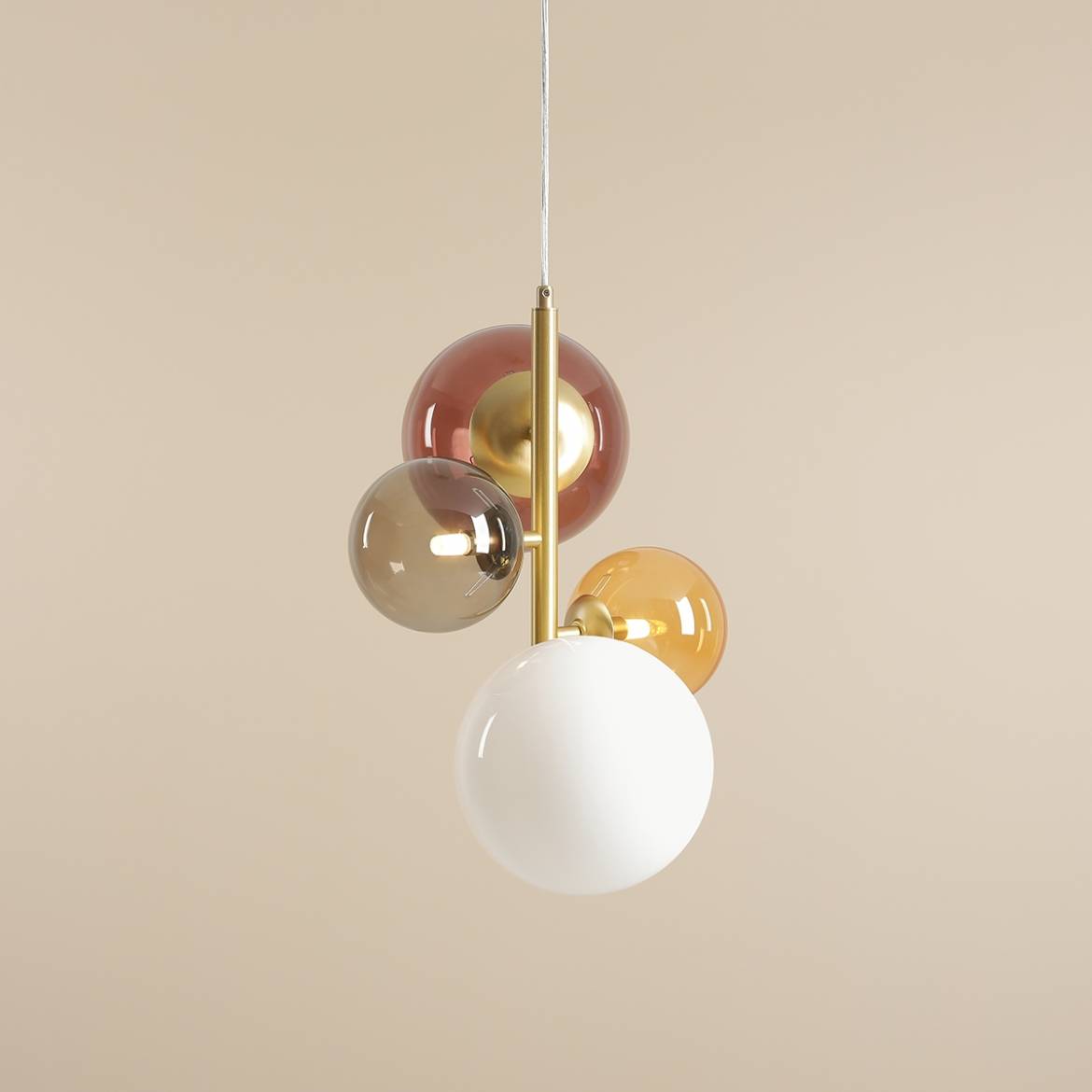Lampa wisząca Bloom Multikolor z czterema kulistymi kloszami w odcieniach białym, brązowym, szarym i złotym, zawieszona na złotej konstrukcji. Klosze różnej wielkości, umieszczone w artystycznym układzie, na tle neutralnej, jasnej ściany.