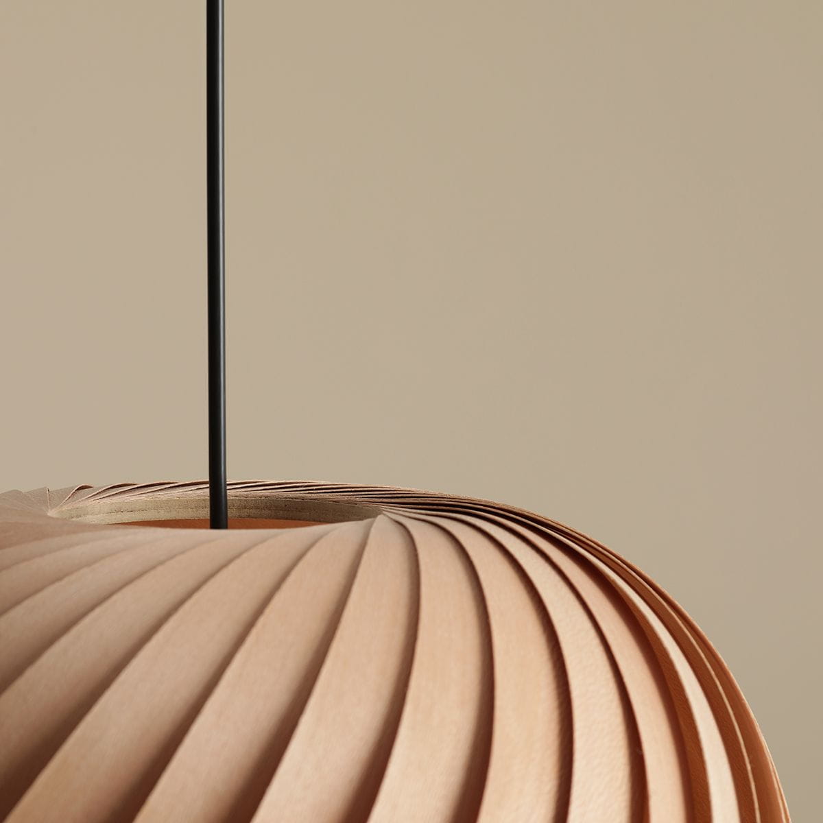 Lampa wisząca Nature Dark D38 w kolorze jasnobrązowym z teksturowanym kloszem o falistym kształcie, zawieszona na cienkim czarnym przewodzie. Widok z góry, ukazujący detale i strukturę materiału. Tło w odcieniu jasnego beżu.