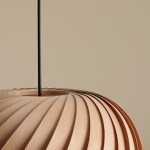 Lampa wisząca Nature Dark D38 w kolorze jasnobrązowym z teksturowanym kloszem o falistym kształcie, zawieszona na cienkim czarnym przewodzie. Widok z góry, ukazujący detale i strukturę materiału. Tło w odcieniu jasnego beżu.