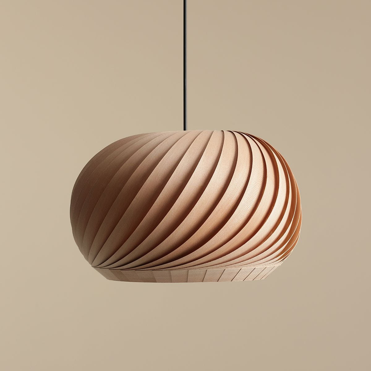 Lampa wisząca Nature Dark D38 o kształcie owalnym, wykonana z drewna, z charakterystycznymi spiralnymi żłobieniami. Zawieszona na cienkim kablu, prezentuje się na jednolitym tle. W kolorze jasnego drewna, idealna do nowoczesnych wnętrz.
