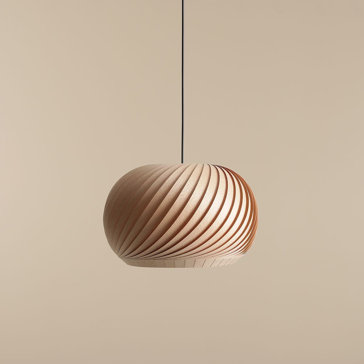 Lampa wisząca Nature Dark D40 o okrągłym kształcie, wykonana z drewna, z charakterystycznym spiralnym wzorem. Zawieszona na cienkim czarnym przewodzie, na jednolitym, jasnym tle. Idealna do nowoczesnych wnętrz.