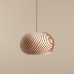 Lampa wisząca Nature Dark D45 ma zaokrąglony klosz z lameli w jasnym drewnie, o spiralnym wzorze. Zawieszona na cienkim czarnym przewodzie, idealna do nowoczesnych wnętrz. Tło w jednolitym jasnym kolorze podkreśla elegancję lampy.