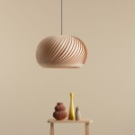 Lampa wisząca Nature Dark D45 w kształcie kulistym, wykonana z jasnego drewna, z charakterystycznym spiralnym wzorem. Zawieszona na cienkim przewodzie, w zestawieniu z dekoracyjnymi wazonami na stoliku. Tło w odcieniu beżowym.