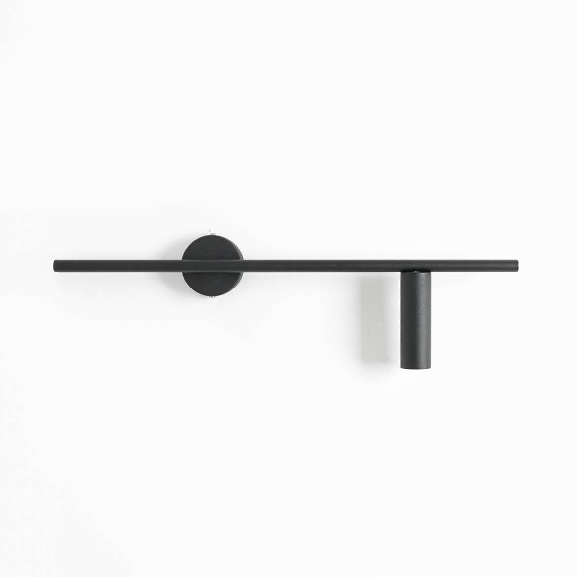 Czarny kinkiet Trevo 1-punktowy, zamontowany na ścianie, z poziomą, prostą belką oraz pionowym kloszem. Kinkiet ma minimalistyczny design, wykonany z matowego metalu, idealny do nowoczesnych wnętrz.