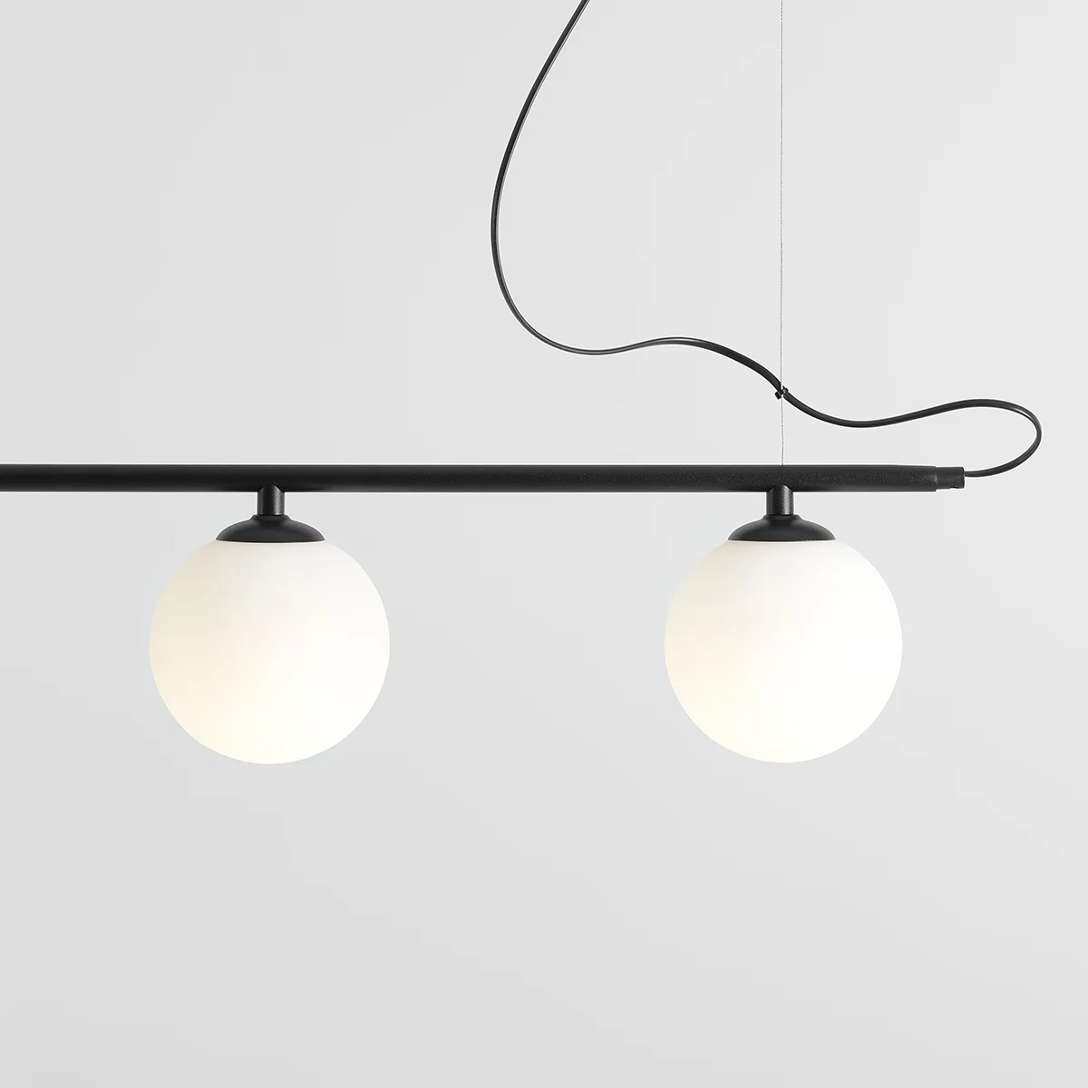 Lampa wisząca Beryl Glass 5-punktowa w kolorze czarnym. Składa się z prostokątnej, czarnej listwy z pięcioma białymi, okrągłymi kloszami. Klosze wykonane z matowego szkła, zawieszone na cienkich, czarnych przewodach. Prosty, nowoczesny design.