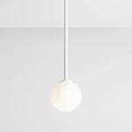 Biała lampa wisząca Pinne Medium z okrągłym kloszem, zawieszona na cienkim, białym przewodzie. Klosz ma matową powierzchnię, emitując miękkie światło. Produkt prezentowany na jednolitym, jasnym tle.