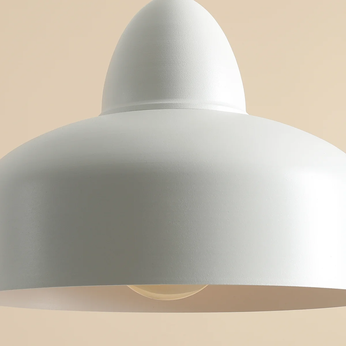 Lampa wisząca Como White 1-punktowa, w kolorze białym, o zaokrąglonym kształcie z lekko wypukłym kloszem. Widoczna żarówka w środku. Ujęcie z góry, na jednolitym tle.