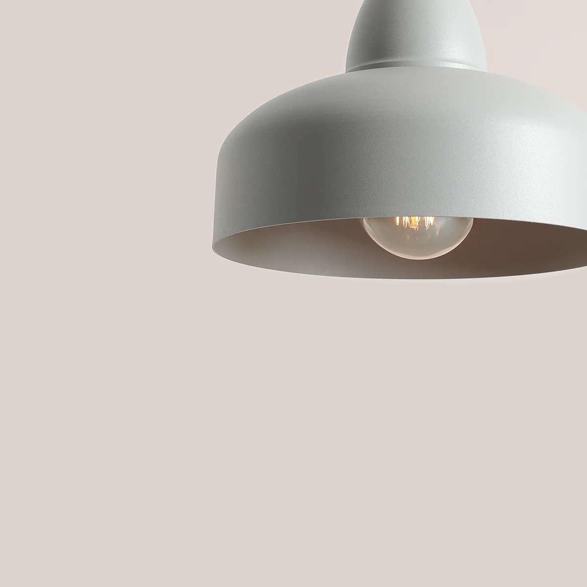 Lampa wisząca Como Gray w kolorze szarym, z metalowym kloszem o zaokrąglonym kształcie, z widoczną żarówką w środku. Kąt ujęcia z góry, na jednolitym tle.