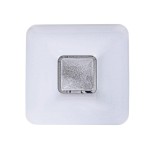 Plafon Yax LED D44/24W w kształcie kwadratu, z białą, lekko teksturowaną obudową i metalowym, srebrnym detalem na środku. Produkt z możliwością ściemniania, z pilotem, o temperaturze barwowej 3000-6000K. Ujęcie z góry.