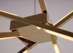 Złota lampa wisząca Spider LED, 3-punktowa. Ujęcie zbliżeniowe na centralną część, pokazującą geometryczny kształt i lśniące, gładkie wykończenie. Widoczne metalowe ramiona o nowoczesnym designie, podkreślające elegancję produktu. Tło jasne, neutralne.
