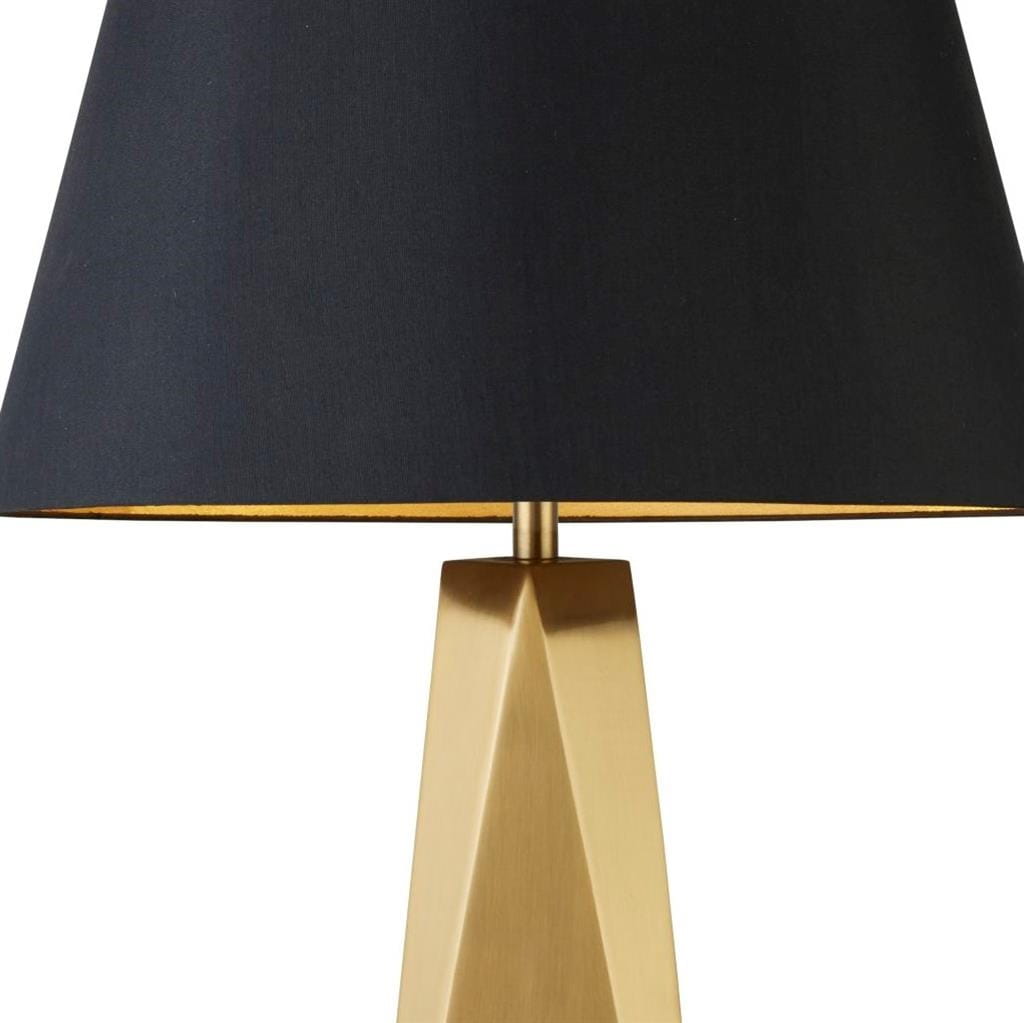 Złota lampa stołowa Maldon z geometryczną podstawą i czarnym abażurem, widoczna z boku. Abażur ma złote wnętrze, co podkreśla elegancki design lampy. Idealna do nowoczesnych aranżacji wnętrz.