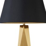 Złota lampa stołowa Maldon z geometryczną podstawą i czarnym abażurem, widoczna z boku. Abażur ma złote wnętrze, co podkreśla elegancki design lampy. Idealna do nowoczesnych aranżacji wnętrz.